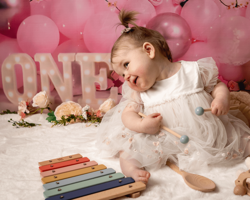 little girl looking cheeky in front of a xylophone