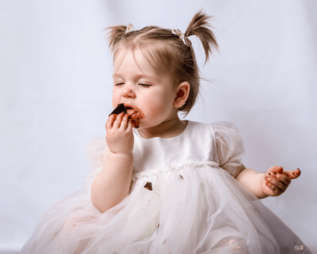 a little girl really enjoying some chocolate cake
