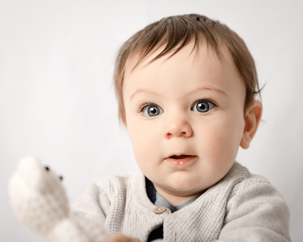 baby boy holding a little white bear